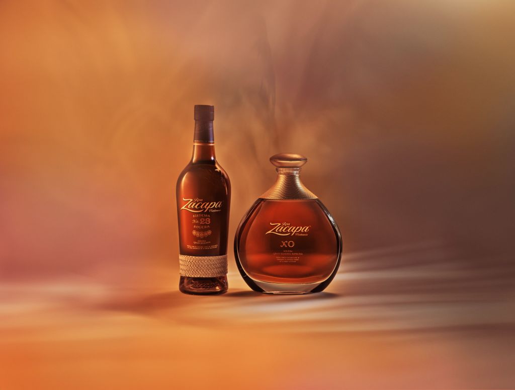 Two bottles of Zacapa rum, one labeled "XO" and the other "23", against an orange and brown background.