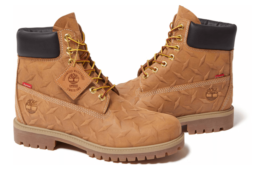 Pair of tan Timberland boots with a crinkled, textured pattern and gold lacing.