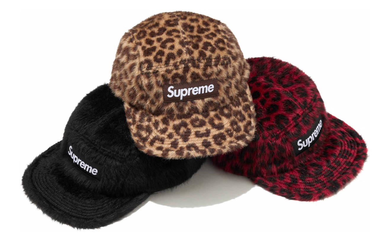 Assorted Supreme-branded hats in leopard print, black, and red patterns.