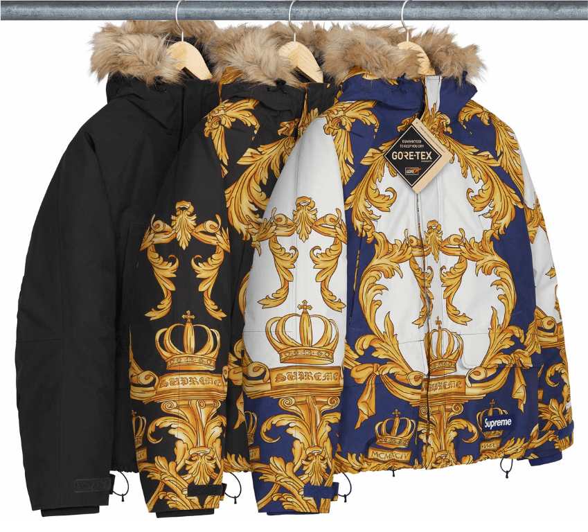Rack of colorful hooded jackets with ornate gold and blue floral patterns and crown designs, labeled "Gore-Tex".