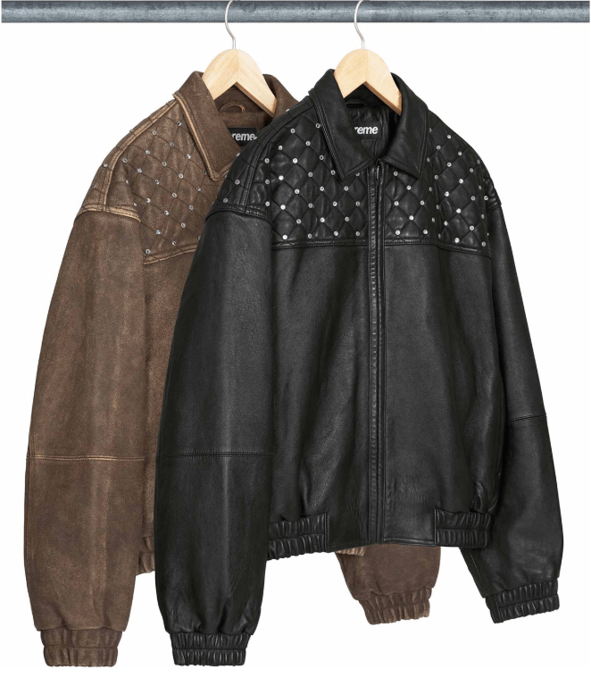 Two leather jackets hanging on a clothing rack, one brown and one black with white polka dots.