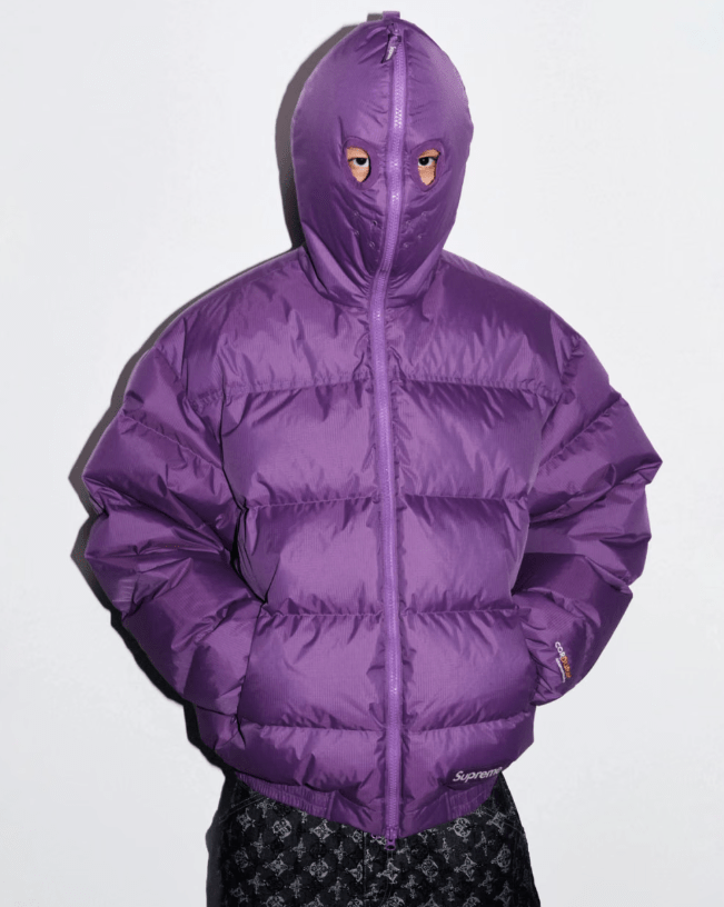 A purple hooded puffer jacket with large yellow eyes visible through the hood.