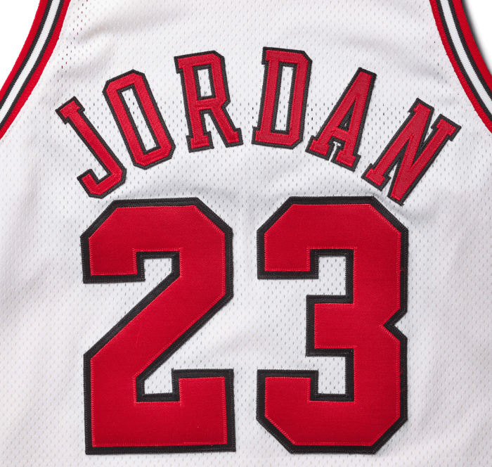 A white basketball jersey with the name "JORDAN" and the number "23" in red.