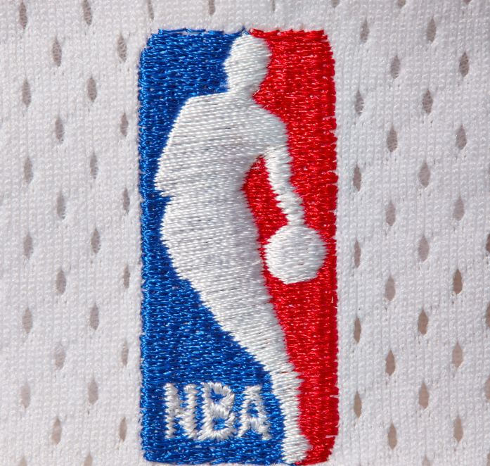 Embroidered NBA logo on a gray and white patterned fabric.