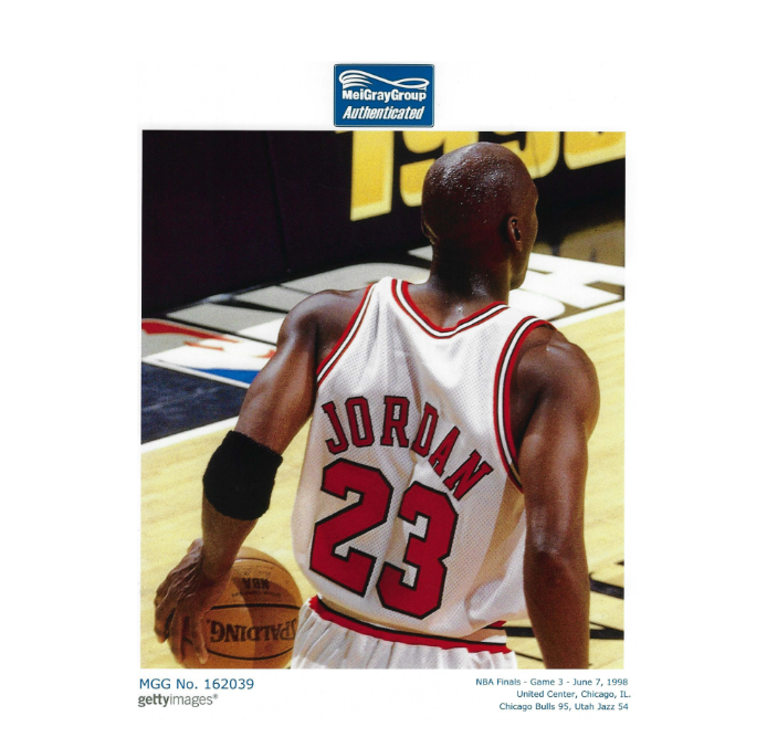 A basketball player wearing a jersey with the number 23 and the name "Jordan" on it, holding a basketball on a basketball court.
