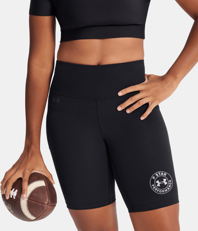 A person wearing black athletic clothing and holding a football, with the Under Armour logo visible on the shorts.