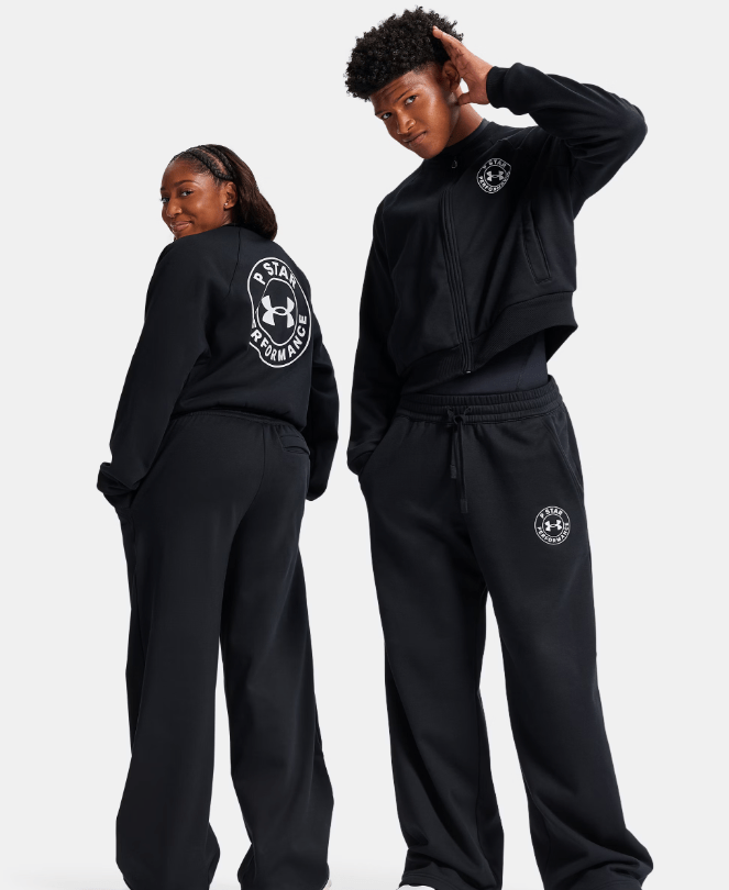 Two people wearing black Under Armour hoodies and sweatpants standing together.