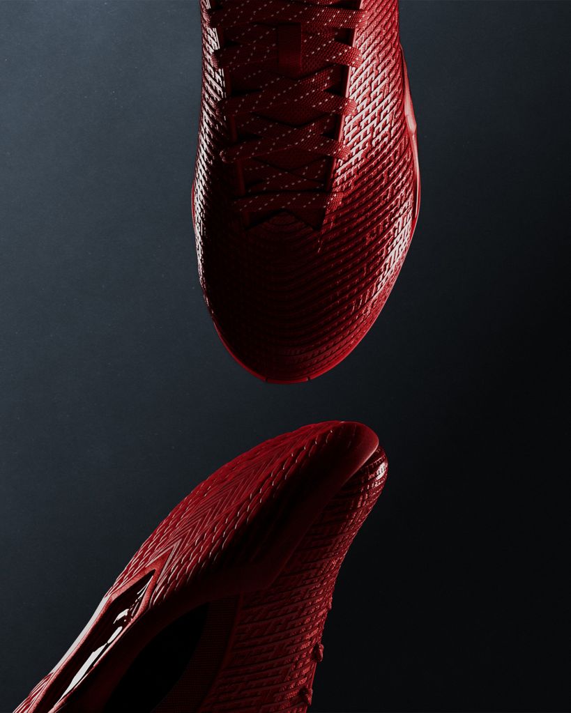 Close-up of a red, textured athletic shoe with a distinctive pattern.