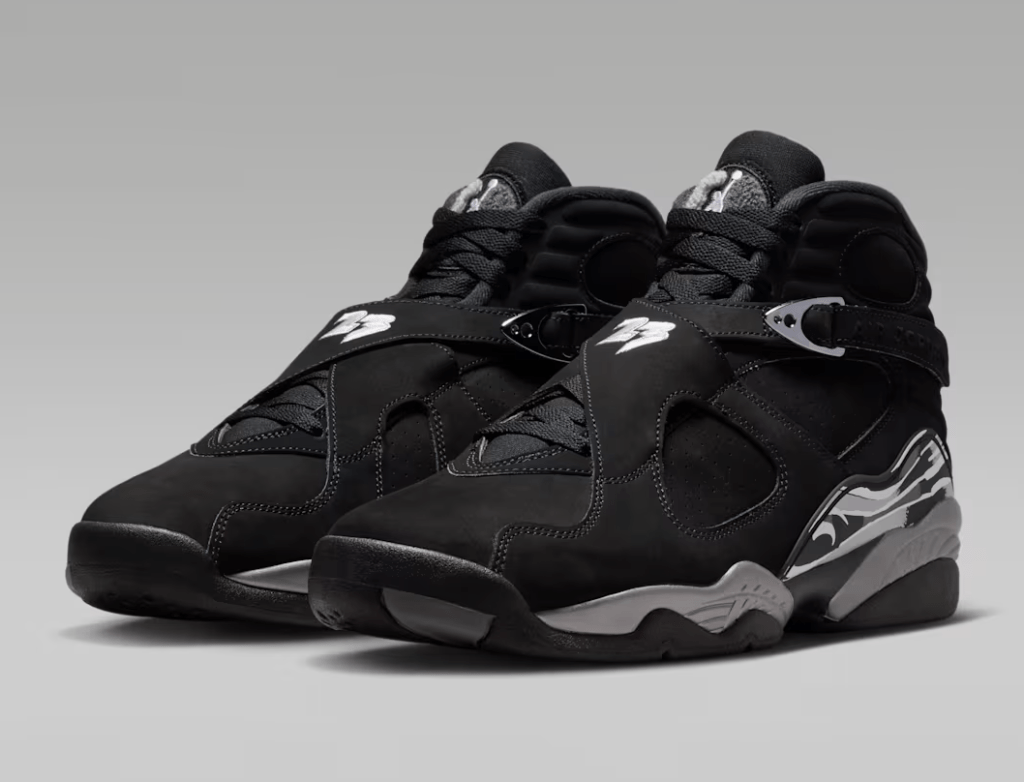 A pair of black and gray Nike Air Jordan 8 sneakers with distinctive straps and branding.